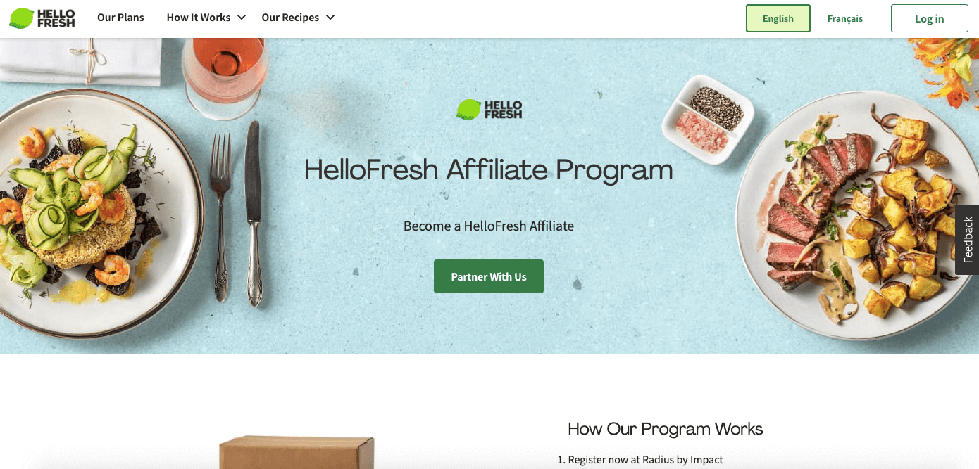 Screenshot of the “HelloFresh Affiliate Program,” featuring a few gourmet dishes, drinks, and spices on a blue table.