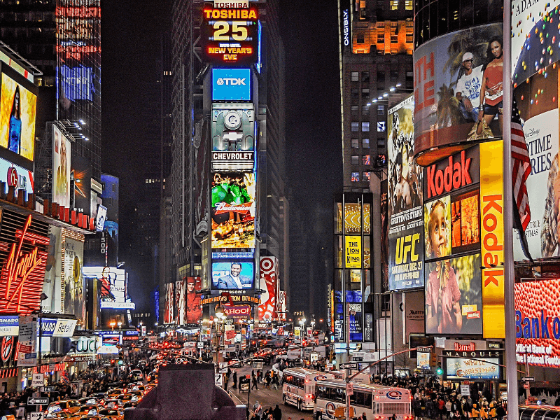 This image displays the bright lights of New York City’s Times Square with its many classic billboard advertisements.