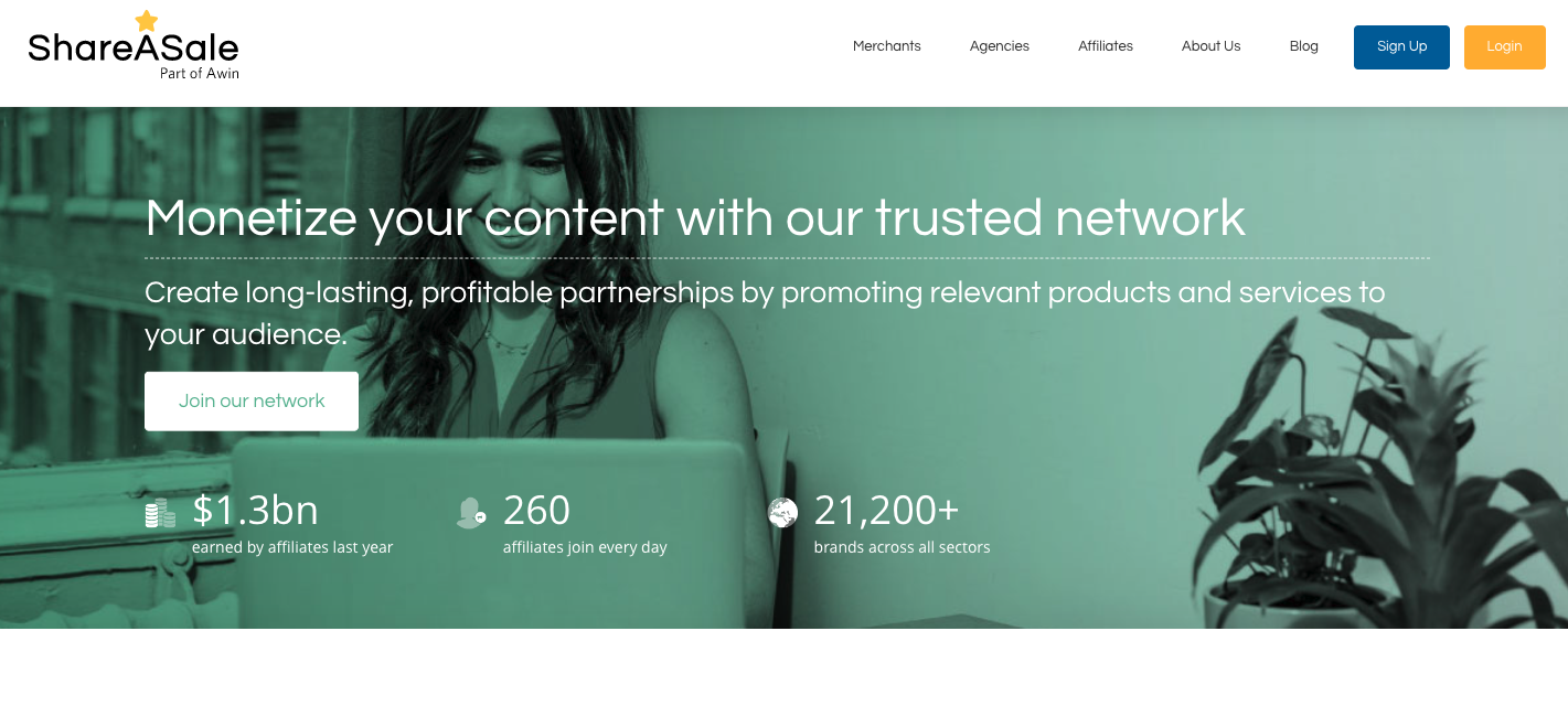 The image displays the ShareASale homepage stating users can monetize their content with their trusted network. The background is a photo of a woman sitting at her computer.