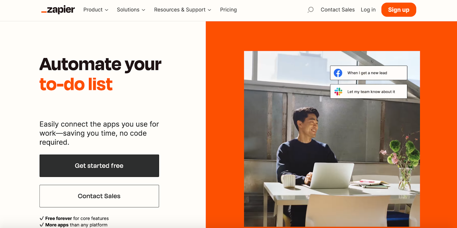 A screenshot of the Zapier homepage, featuring a photo of a man sitting at the table with a laptop.